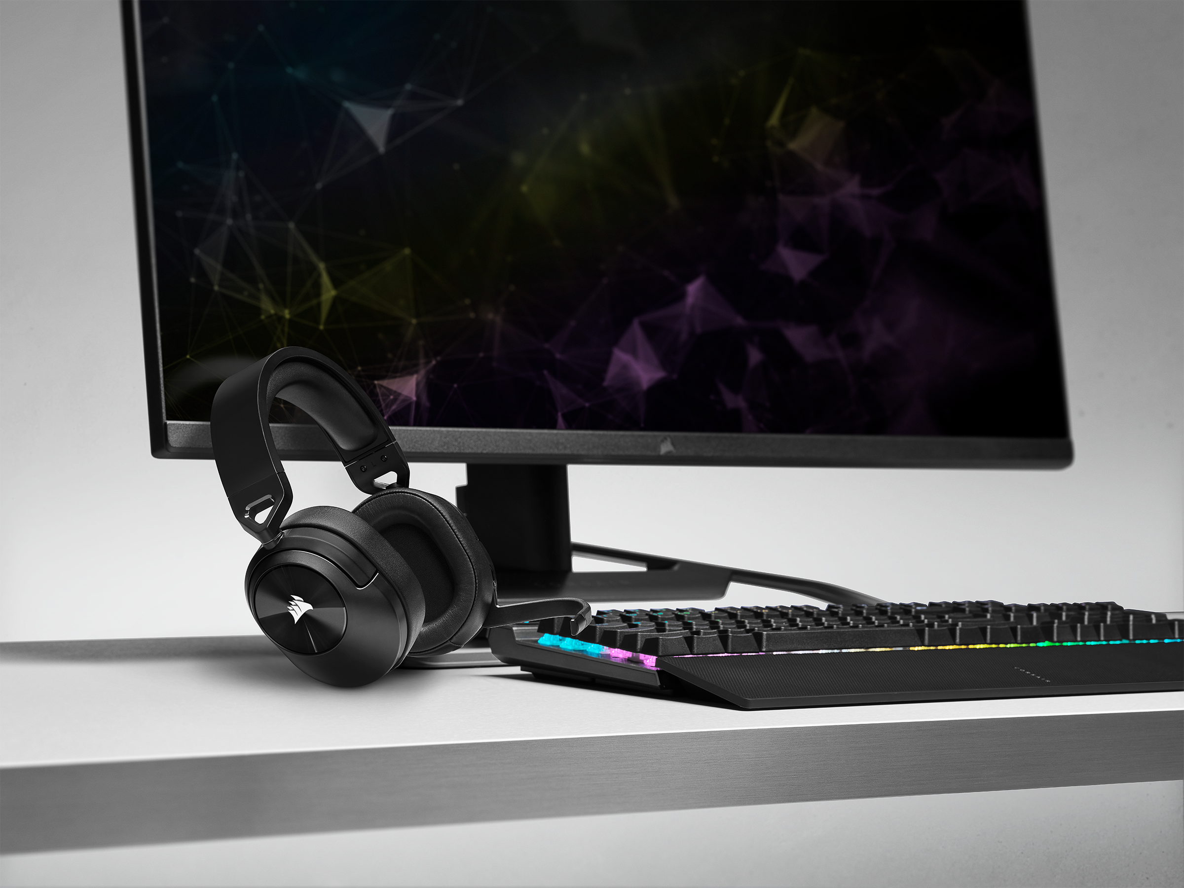 The HS55 WIRELESS CORE gaming headset sits on a desk next to a gaming keyboard and mouse.